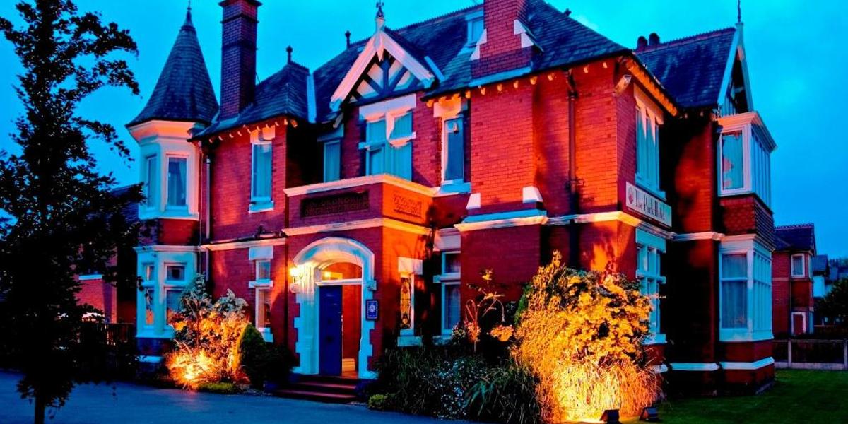 Main image: The Park Hotel Exterior of The Park Hotel, lit up at night.