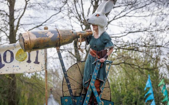 Performer with rabbit head costume stood by giant telescope during performance at 2022 Egg Rolling.