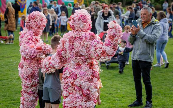 Entertainment duo on Avenham Park, dressed in full costume made of flowers during 2022 Egg Rolling.