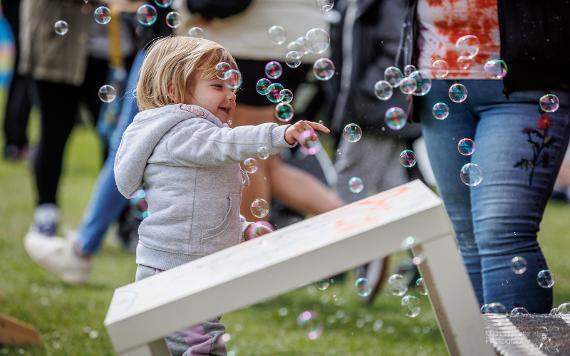 Child catching bubbles at 2022 Egg Rolling event.