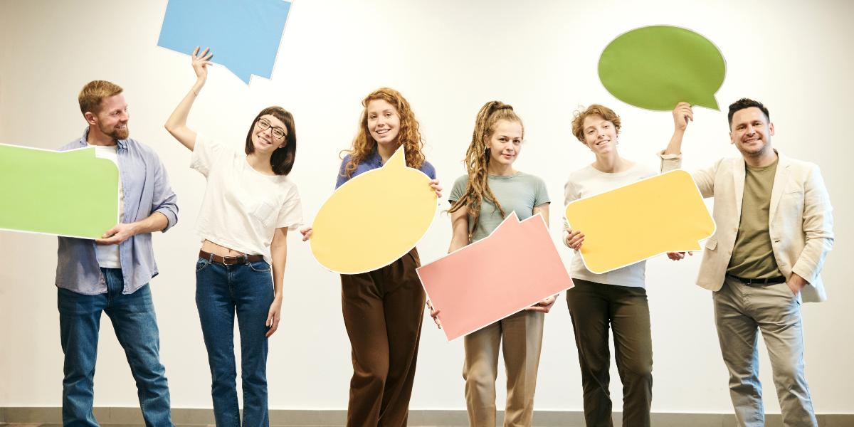 Main image: Lancashire Humanists Group of people holding large speech bubbles.