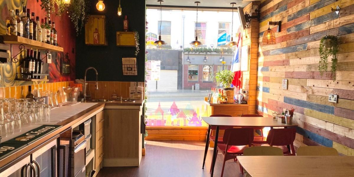 Main Image: Interior Looking out to street A view of the outside from inside Itsy's Street Food restaurant with seating area
