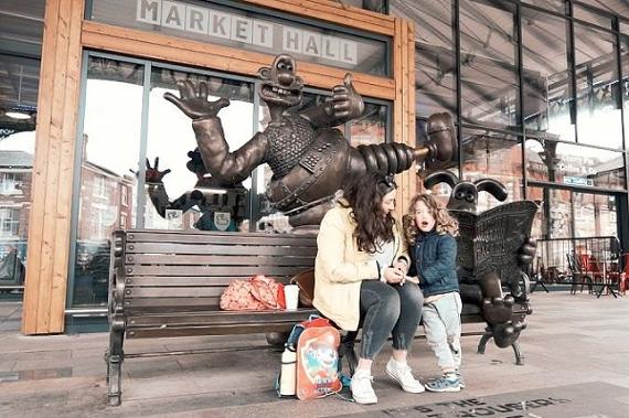 Mother and child on the Wallace and Gromit bench at Preston Markets