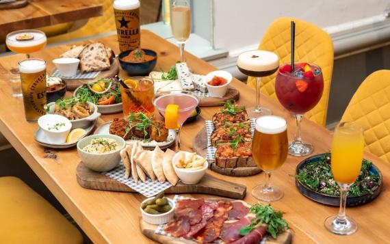 A bottomless brunch serving at Fino Tapas featuring lots of charcuteria meats, breads, croquettes and alcoholic drinks