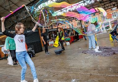 Child creating giant bubble