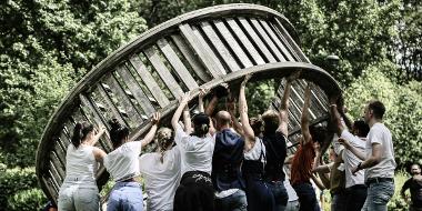 Parade performers lifting giant wheel