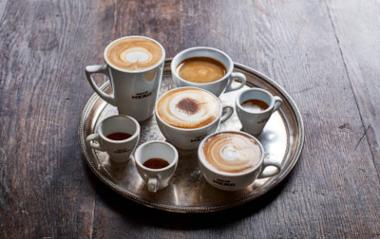 A tray of various sizes and types of coffee on a table inside Caffé Nero