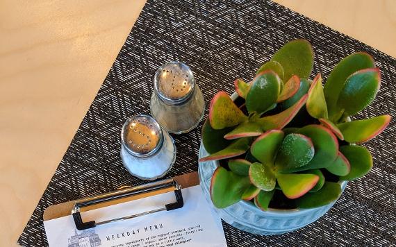 Plant and menu on the table inside Brew + Bake café.