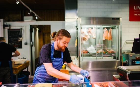 Butcher behind the counter at Livesey's Butchers in Preston Markets.