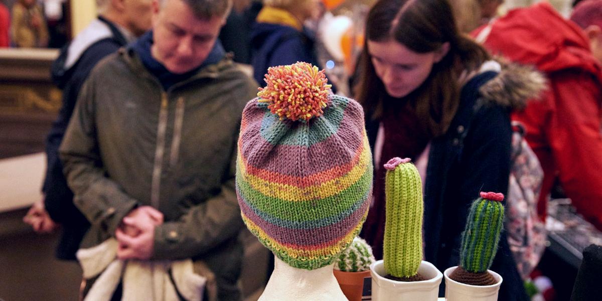 Hat and knitted cacti on market stall at Harris Etsy makers market.