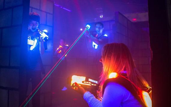 Boy getting ready to shoot opponent inside Laser Quest arena.