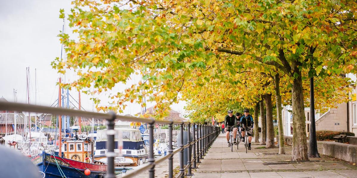 Main image: Men cycling along path at Preston docks. Men cycling along path at Preston docks.