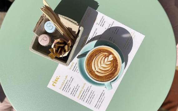 Rise coffee and menu on outdoor table.