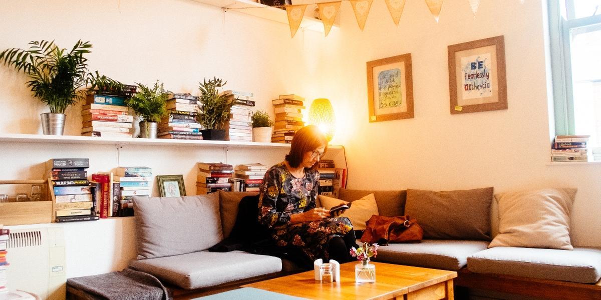 Main image: Woman sat inside Town House Coffee and Brew Bar, surrounding by books. Woman sat inside Town House Coffee and Brew Bar, surrounding by books.
