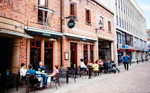 Diners outside Forum on sunny day.