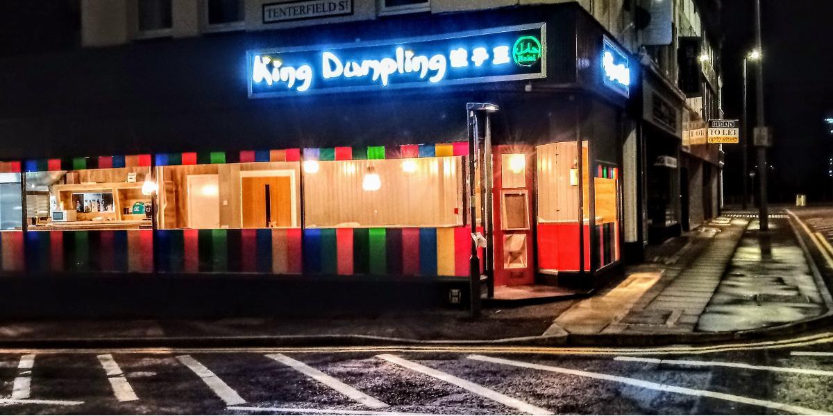 Main image: Outside King Dumpling restaurant, lit up at night. Outside King Dumpling restaurant, lit up at night.