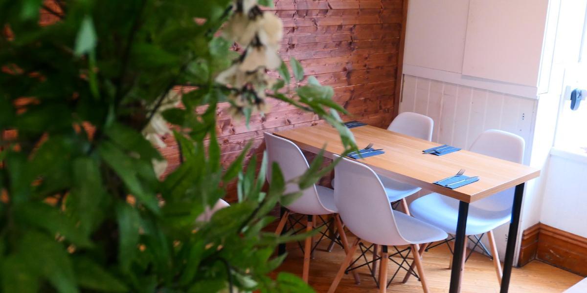 Main image: Kimji's downstairs dining area with plants and wooden walls. Kimji's downstairs dining area with plants and wooden walls.