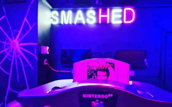 Smashed neon sign with Goldeneye game inside Nintendo 64 in foreground.