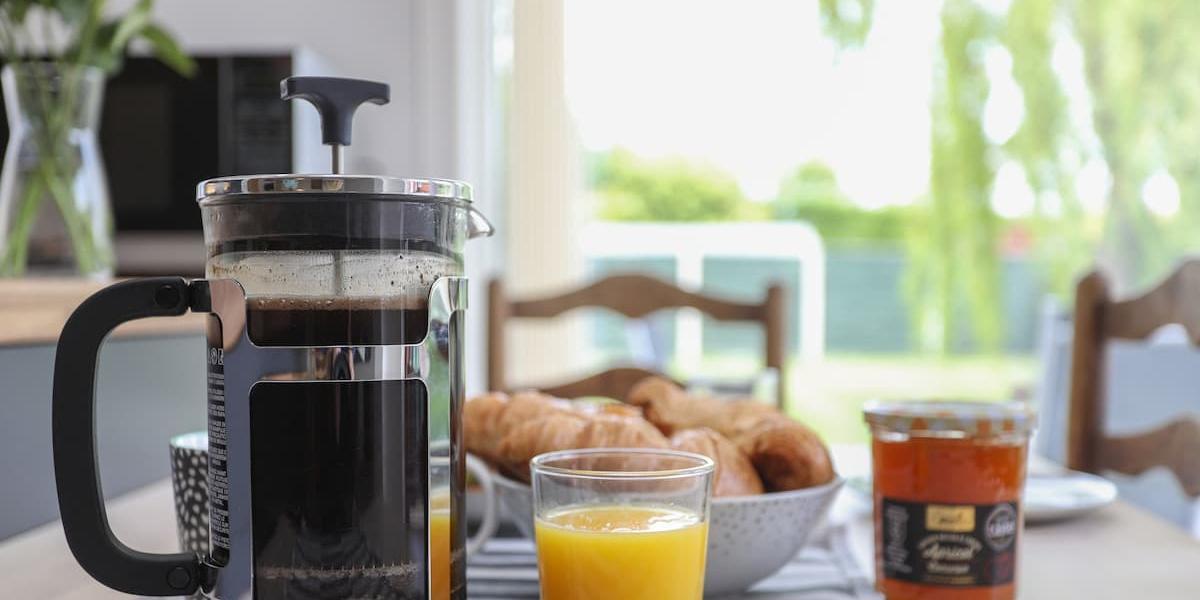 Cafetiere, orange juice, and croissants on kitchen table in one of Bedzzz locations. Cafetiere, orange juice, and croissants on kitchen table in one of Bedzzz locations.