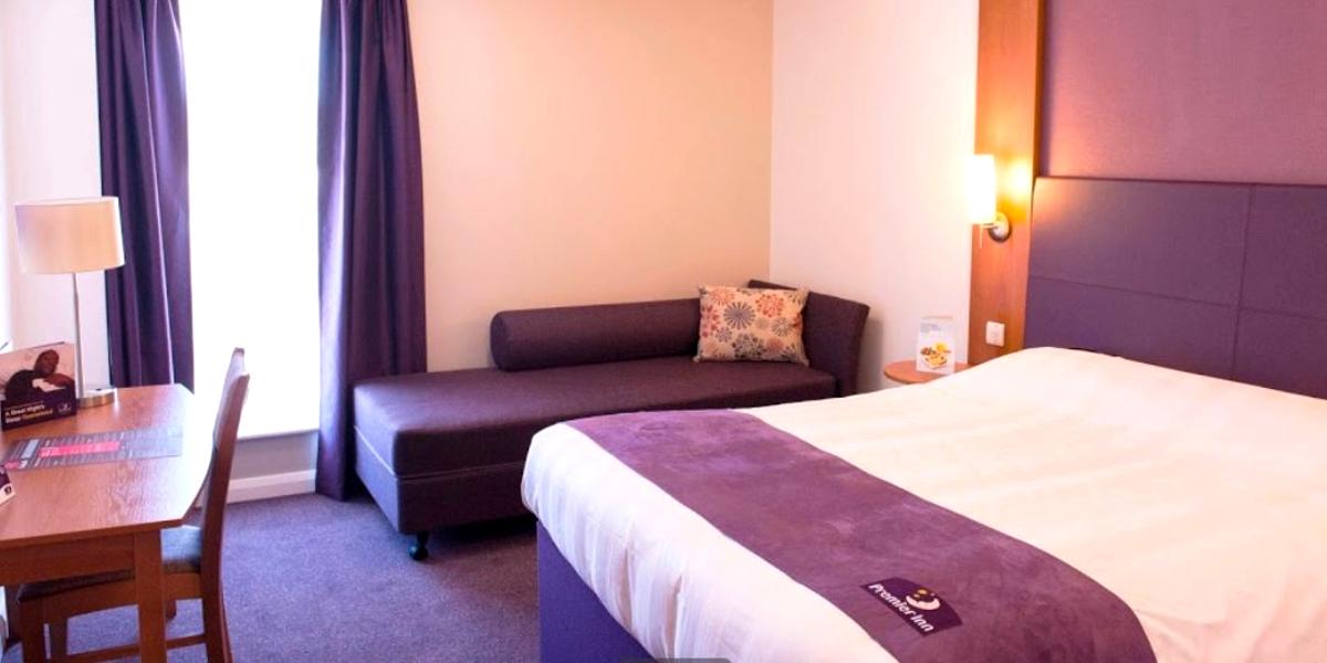 Main image: Purple and white hotel room at Preston Central Premier Inn. Purple and white hotel room at Preston Central Premier Inn.