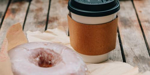 Page icon: Take away coffee and doughnut on a picnic table outdoors. Take away coffee and doughnut on a picnic table outdoors.