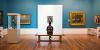 Man sat on bench admiring painting on wall inside Harris Gallery, Preston.