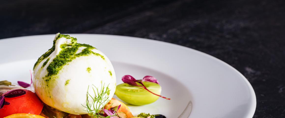 Poached egg dish on plate against black background.
