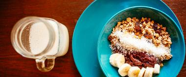 Smoothie bowl and fruit juice on a table inside Cafuné South American café. 