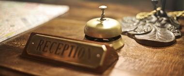 Reception sign and bell inside bed and breakfast accommodation.