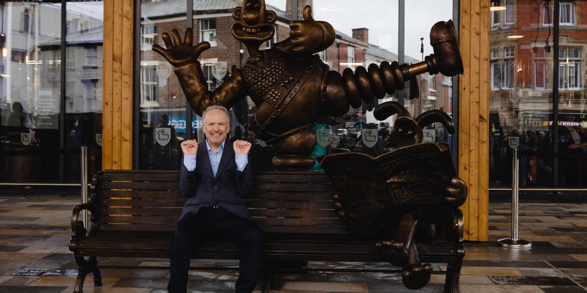 Main image: Nick Park bench Nick Park sat on Wallace and Gromit bench at Preston Markets.