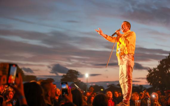Freddie Mercury from Queen tribute act performing on stage during sunset at Rockprest festival.